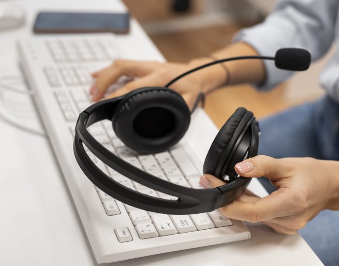 woman-working-call-center-holding-pair-headphones